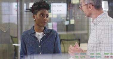 Explaining consultant in plaid and colleague in denim gesturing in boardroom, with chart overlays. Collaboration, communication, teamwork, innovation, modernity, strategy, business