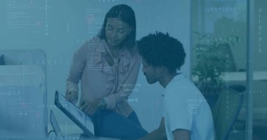 Pointing woman and man in business attire reviewing code at work desk, with monitor keyboard mouse. Collaboration, innovation, technology, professional, teamwork, contemporary, startup
