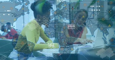 Dört öğrenci çalışma masasının etrafında dizüstü bilgisayarlarla, ders kitaplarıyla dijital kaplamalarla iş birliği yapıyor. İşbirliği, takım çalışması, yenilik, dijital, eğitim, beyin fırtınası, bilgi