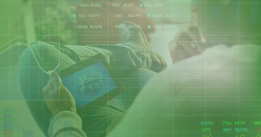 Oturma odasında dijital grafiklerle kaplanmış planlar sergilenen tableti tutan yaslanmış tasarımcı. Teknoloji, yenilik, modern, çalışma alanı, dijital, yaratıcılık, profesyonel