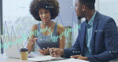 Colleagues discussing printed charts holding pens in office, with laptop, coffee cup and overlays. Collaboration, teamwork, analytics, startup, workspace, innovation, productivity