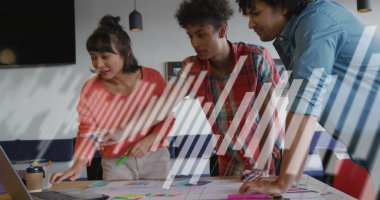 Pointing woman in sweater guiding team in office, with laptop, printed materials, coffee cup. Collaboration, strategy, brainstorming, teamwork, professional, modern, office