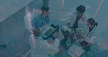 Analyzing team in scrubs, white coats reviewing documents in conference room, with laptops, tablet. Collaboration, professionalism, healthcare, teamwork, analysis, clinical, communication