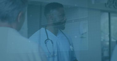 Doctor in light blue scrubs checking data in hospital hallway, with stethoscope and digital overlay. Medical, healthcare, technology, diagnostics, collaboration, modern, innovation