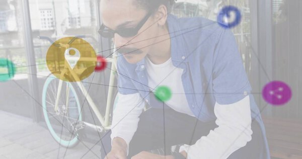 crouching man wearing sunglasses and clothes leaning on glass facade, with bicycle digital overlay. Urban, technology, connectivity, mobility, innovation, modern, style