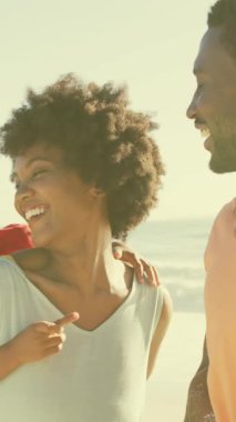 Gülümseyen Afro-Amerikan ailesinin plajda eğlenmesi üzerine Amerikan bayrağının yıldızlarla canlandırılması. Dijital bileşim, çoklu pozlama, aşk, birliktelik, tatil, özgürlük, hükümet ve vatanseverlik..