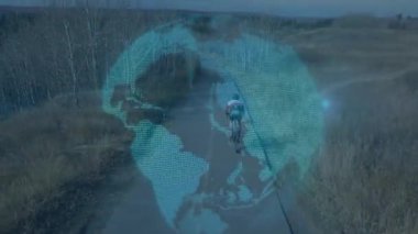 Bisikletçi pedal çevirerek dönen küre altında giderek küçülen teknolojinin düşüşünü gösteriyor. Açık hava, macera, yenilik, manzara, seyahat, teknoloji, sürdürülebilirlik