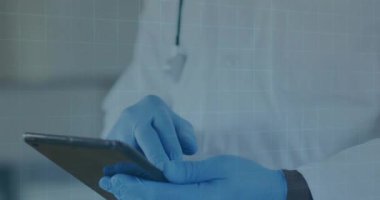 Tıp laboratuarında tablet ekranını tıkırdatan kıdemli erkek doktor holografik çizelgeler ve dünya haritasını çağırıyor. Tıbbi teknoloji, dijital sağlık, klinik veriler, gelecekteki arayüz, sağlık hizmetleri yeniliği, profesyonel sağlık hizmetleri, teşhis