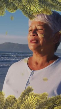 Plajdaki bir kadın için yılbaşı süslerinin animasyonu. Noel, gelenek, kutlama ve şenlik kavramı dijital olarak oluşturuldu.