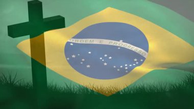 Hafif bir meltem çimenleri karıştırıyor ve Brezilya bayrağı sallarken haç silueti de amblemi onurlandırıyor. Vatanseverlik, milliyetçilik, hareket, kumaş, sembolizm, açık hava, manzara