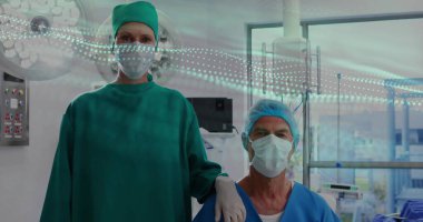 Monitoring patient vitals on monitor in operating room, with overhead surgical light and window. Medical, healthcare, clinical, professionalism, equipment, teamwork, innovation