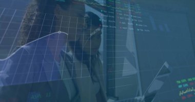 İş elbiseleri giymiş iş arkadaşları vitrinde dizüstü bilgisayar ve kaplamalarla finans tabloları okuyorlar. Şirket, takım çalışması, veri, analiz, modern, profesyonel, teknoloji