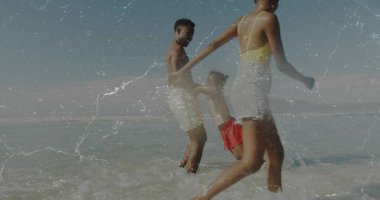 Running family holding hands through shallow ocean water at sandy beach, with swimwear and waves. Leisure, togetherness, relaxation, outdoor, natural, vibrant, joy
