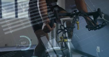 Pedaling cyclist wearing jersey on exercise bike in gym by window blinds, with performance overlays. Fitness, indoor training, health, wellness, technology, athletic, motivation