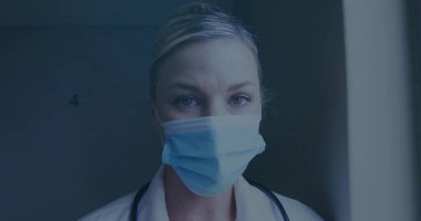 Standing doctor adjusting surgical mask and lab coat in hospital hall, with stethoscope and door 4. Healthcare, professionalism, clinical, diagnostic, hospital, healthcare worker, medical environment