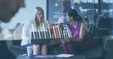 Two colleagues in business attire discussing charts on laptop in office lounge, with coffee cup. Professional, teamwork, collaboration, modern, corporate, innovation, communication