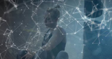 Spor kıyafetlerini spor minderine giymiş, kettlebell ve dijital kaplamalı bir bayan sporcu. Fitness, strength, digital, modern, wellness, training, technology