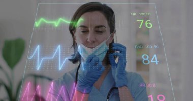 Adjusting nurse in blue scrubs pulling down mask in clinic with gloves stethoscope hologram display. Medical, healthcare, technology, futuristic, diagnostic, professional, clinical