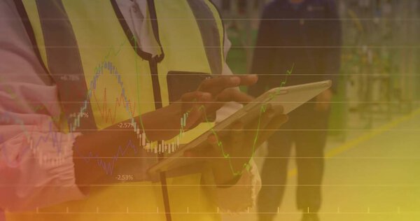 Male worker wearing safety vest using touchscreen tablet in plant, with yellow floor markings. Industrial, teamwork, productivity, safety, technology, logistics, modern