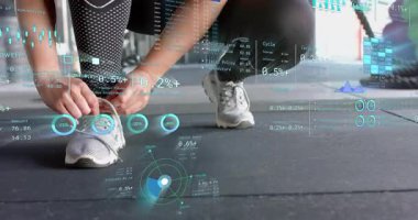 Diz çökmüş, bağcıklarını bağlayan, ayakkabı bağlayan, spor salonunu finans tablosuyla kaplayan bayan sporcu. Sporcu, fitness, antrenman, aktif giyim, spor salonu, dijital çizelgeler, spor