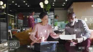 Ofisteki meslektaşlar nişan büyümesini izleyen yüzen sosyal ölçümler raporunu inceliyor. İşbirliği, analitik, takım çalışması, yenilik, modern, profesyonel, üretkenlik