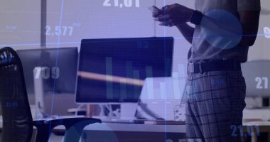 Analyzing man wearing polo shirt using smartphone and monitor for charts in office, copy space. Corporate, analytics, modern, professional, technology, business, data