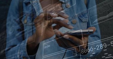 Kot ceket giyen bir kadın karanlık duvarda akıllı telefonla iletişim kuruyor ve veri örtülerini gösteriyor. Teknoloji, dijital arayüz, veri görselleştirme, yenilik, modern, iletişim, görsel efektler