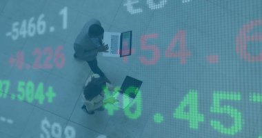Walking business professionals checking market data on laptops across office lobby, stock overlay. Corporate, finance, technology, data, teamwork, modern, professional