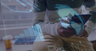 Multitasking man in shirt, khaki pants holding smartphone and tablet at office, with data overlay. Technology, data visualization, workspace, professional, modern, digital, analysis