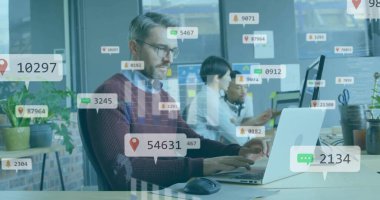 Açık ofisteki gümüş dizüstü bilgisayarda, üzerinde monitörler, yüzen örtüler olan bordo bir kazak giyiyor. İşbirliği, teknoloji, yenilik, üretkenlik, takım çalışması, modern, profesyonel