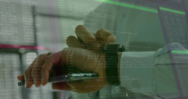 IT pro's hand pointing stylus at tablet in IT office, with smartwatch and monitors displaying code. Technology, software, cybersecurity, digital, workspace, innovation, programming