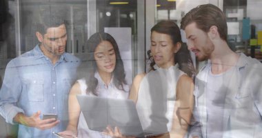 Ofisteki dizüstü bilgisayarın içeriğini akıllı telefon ve cam bölümlerle inceleyen iş arkadaşları. Takım çalışması, yenilik, modernlik, üretkenlik, iletişim, profesyonel, başlangıç