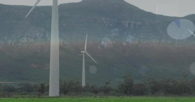 Üçüncü saniyeden başlayarak, rüzgar türbinleri dönüyor ve dijital grafikler zayıflıyor, enerji verilerini görselleştiriyor. Yenilenebilir, sürdürülebilirlik, analitik, çevre dostu, teknoloji, gelecekçilik, çevre