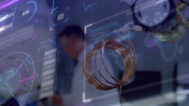 Üst düzey erkek araştırmacı notları yazarken laboratuardaki bakır bobinlerdeki gösterge değişimlerini gözlemliyor. Teknoloji, yenilik, ölçüm, tanı, veri analizi, hassasiyet, mühendislik