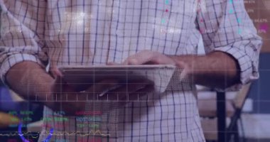 Orta yaşlı bir adam tableti tıklatıyor ve piyasa değerlerini karşılaştırırken finansal veri örtüsü oluşturuyor. Teknoloji, analitik, iş, profesyonel, dijital, iletişim, modern