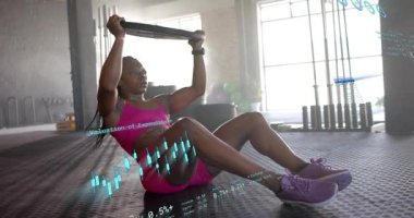 Spor salonunda ağırlık plakasını kavramış bir kadın oturmayı başlatıyor ve çekirdek dayanıklılığı için tabağa bastırıyor. Zindelik, güç, egzersiz, sağlık, motivasyon, eğitim, canlılık