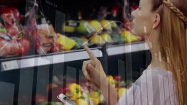 Akıllı telefon kullanan ve pazardan alışveriş yapan mutlu beyaz kadın üzerine finansal verilerin animasyonu. ev finansmanı, ekonomi ve teknoloji konseptiyle dijital olarak üretilen video.