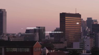 Kamera karanlık gökyüzünün altında ufuk çizgisini açtıktan sonra animasyon çizgileri pencerelerden kayarak geçip soluyor. Şehir, gökyüzü, gece hayatı, gökdelen, yansıtıcı, modern, geometrik