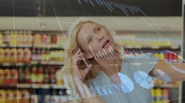 Akıllı telefon kullanan ve pazardan alışveriş yapan mutlu beyaz kadın üzerine finansal verilerin animasyonu. ev finansmanı, ekonomi ve teknoloji konseptiyle dijital olarak üretilen video.