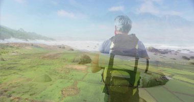 Sırt çantalı, hasırlı bir yürüyüşçü, deniz yosunlarını ve okyanus dalgalarını inceliyor. Macera, keşif, doğa, sükunet, vahşi doğa, manzara, engebeli
