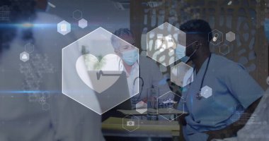 Klinikte maske takan iki doktorun laptopları ve altıgen simgeleriyle hasta verilerini inceliyorum. Tıbbi, işbirliği, modern, sağlık, profesyonel, teknoloji, takım çalışması