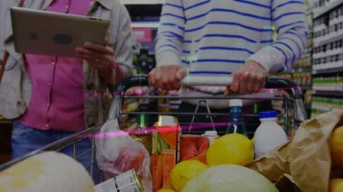 Piyasada tabletle alışveriş yapan farklı çiftlerin orta bölümündeki finansal verilerin animasyonu. ev finansmanı, ekonomi ve teknoloji konseptiyle dijital olarak üretilen video.