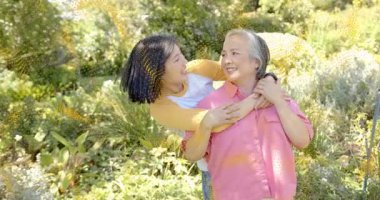 Akıllı çocuklu teknoloji temalı anne bahçeye adım atıp neşe paylaşan kızından destek alıyor. Aile, şefkat, açık hava, yaşam tarzı, sağlık, bağlantı, portre