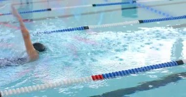 Tura başladıktan sonra, kadın spor salonunda hareketli bir kucak sayacı ile sırt üstü yüzüyor. Sporcu, fitness, aquatic, sport, training, aquatic center, performance