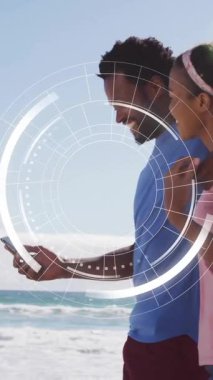 Sahilde akıllı telefonları olan, dijital arayüz animasyonları olan bir çift. Tatil, yaz, teknoloji, artırılmış gerçeklik, aşk, eğlence