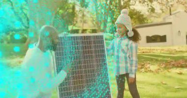 Baba diz çökmüş, kızıyla birlikte güneş enerjisi yakalama hareketine yardım ediyor. Sürdürülebilirlik, yenilenebilirlik, teknoloji, eğitim, yenilik, çevre dostu, aile