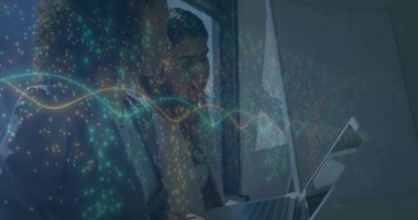 Collaborating businesswomen analyzing glowing waveforms on laptop screen in office by window. Professional, teamwork, innovation, technology, corporate, productivity, modern