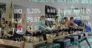 Practicing group of five women performing reformer Pilates in studio, with wall-mounted straps. Fitness, wellbeing, reformer, harmony, exercise, wellness, strength