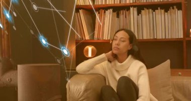 Digital network emerging around woman, friend entering scene offering comfort on sofa in tech. Companionship, emotional support, relaxation, cozy ambiance, digital interface, human connection, warm lighting