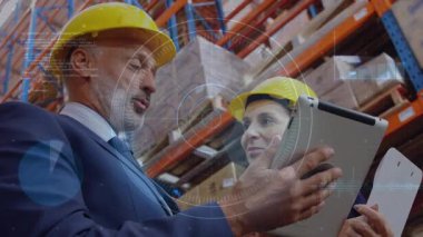 Kasklı bir adam ve kadın ellerinde tabletle depo verilerini titreşimli dijital kaplama ile analiz ediyorlar. İşbirliği, teknoloji, sanayi, takım çalışması, analitik, üretkenlik, şirket